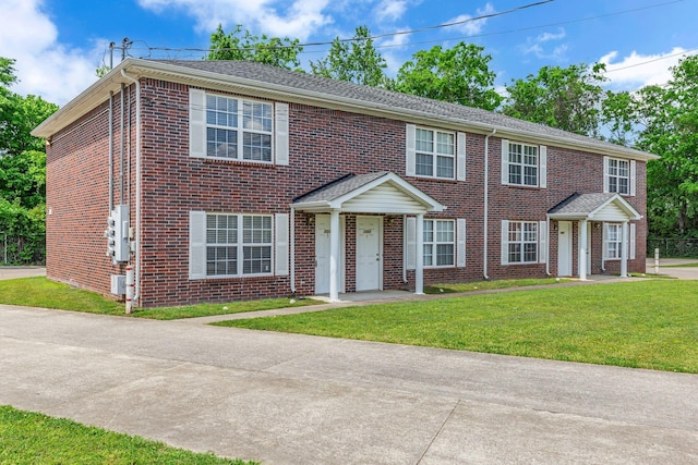 view of front of home featuring a front yard and brick siding