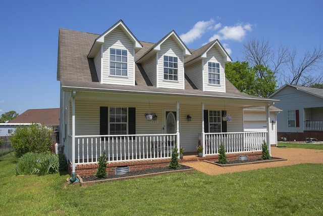 new england style home featuring a porch and a front lawn