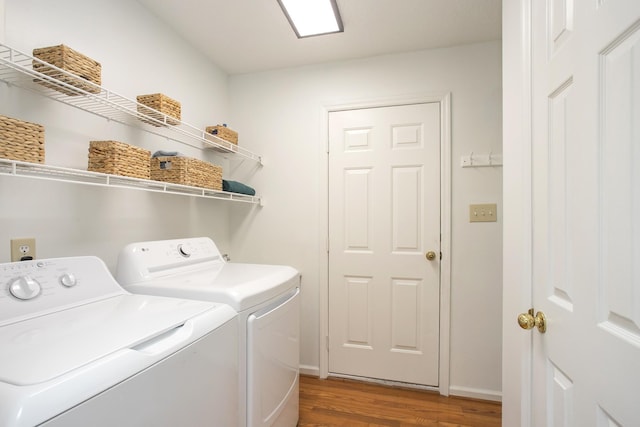 washroom with laundry area, baseboards, washing machine and dryer, and wood finished floors