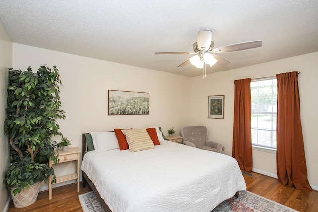 bedroom with baseboards, ceiling fan, and wood finished floors