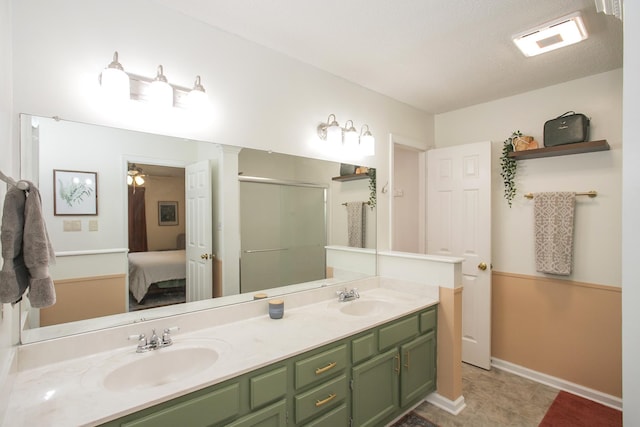full bath with connected bathroom, double vanity, a shower stall, and a sink