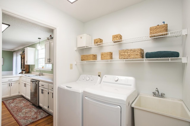washroom with washer and dryer, laundry area, a sink, and wood finished floors