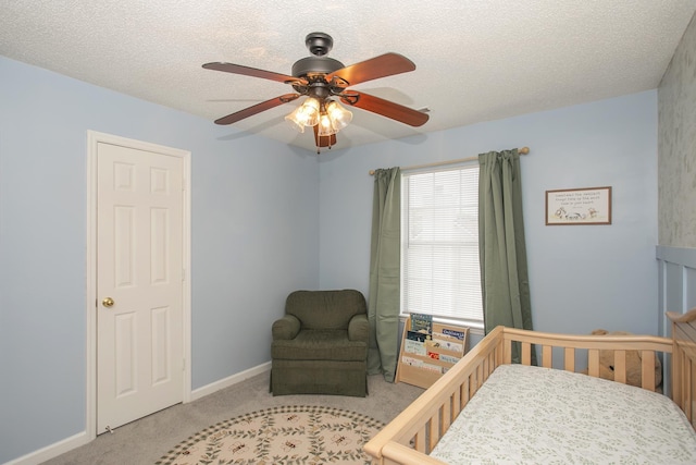 carpeted bedroom featuring a textured ceiling, ceiling fan, and baseboards
