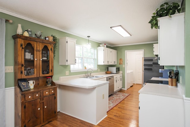 kitchen featuring a sink, crown molding, stainless steel appliances, and white cabinetry