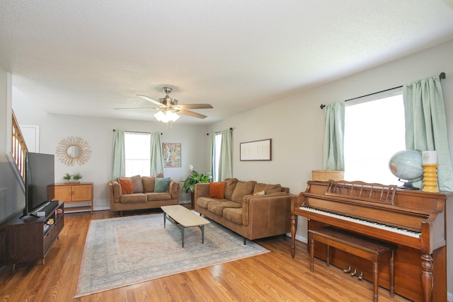 living room featuring a ceiling fan and light wood finished floors