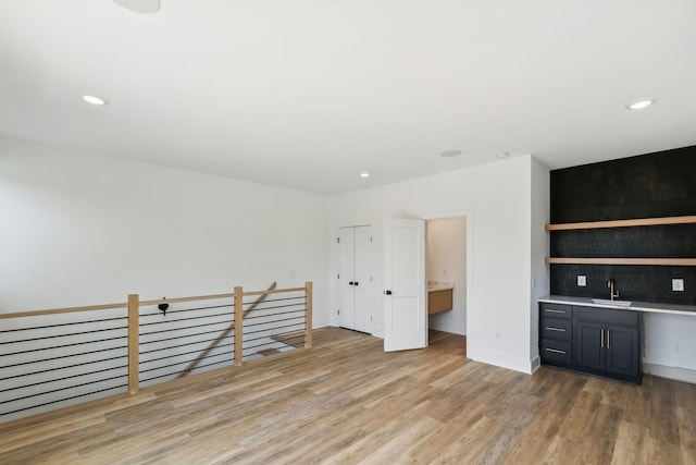 interior space featuring a sink, light wood finished floors, indoor wet bar, recessed lighting, and baseboards