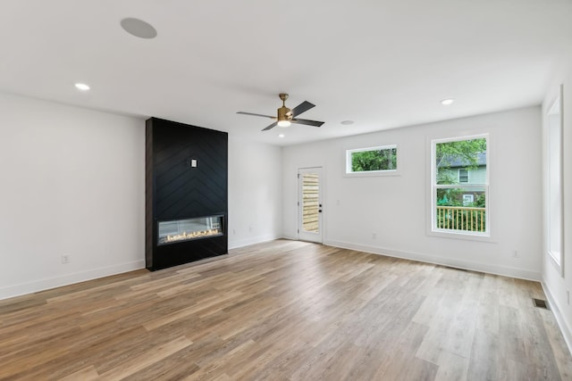unfurnished living room featuring light wood-style floors, a ceiling fan, recessed lighting, and a fireplace