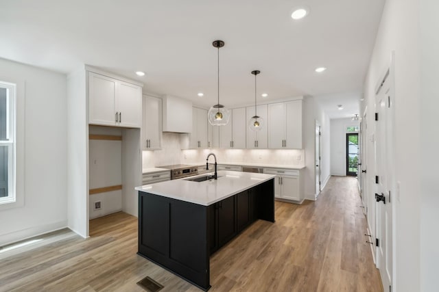 kitchen featuring light countertops, white cabinets, and a sink