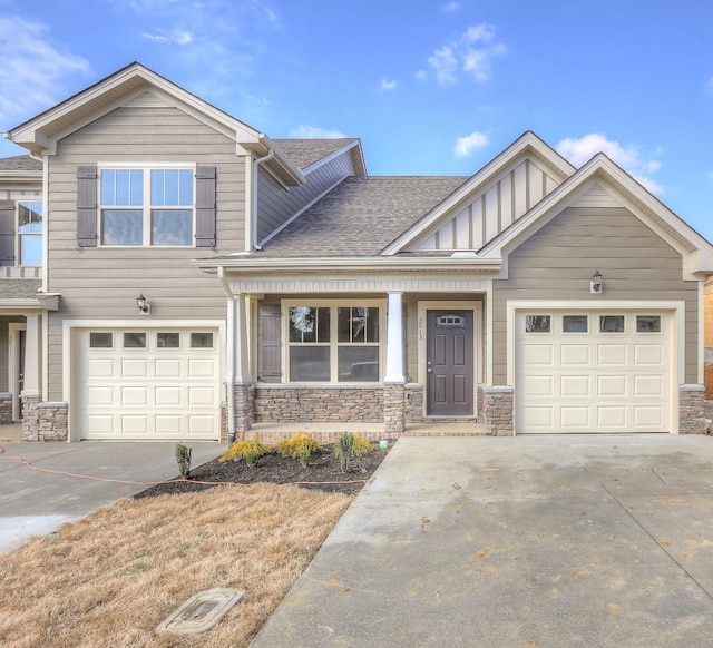 view of front facade with concrete driveway, board and batten siding, and stone siding