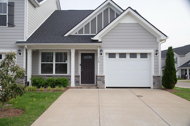 319 Mattie Ln, Spring Hill, TN 37174 - craftsman-style home featuring roof with shingles, stone siding, a garage, a front yard, and driveway