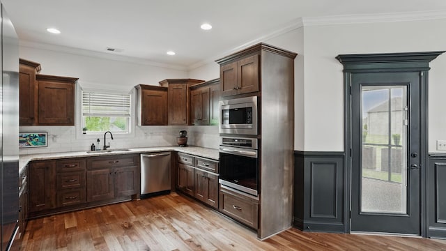 1210 Macey Peri Way, Smyrna, TN 37167 - kitchen with appliances with stainless steel finishes, a sink, wood finished floors, light stone countertops, and ornamental molding