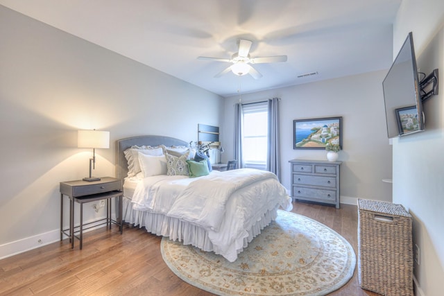 bedroom with visible vents, baseboards, ceiling fan, and wood finished floors