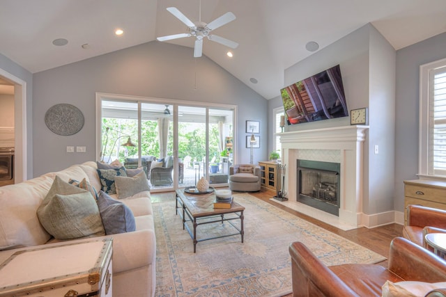 living area with wood finished floors, ceiling fan, high vaulted ceiling, recessed lighting, and a tile fireplace