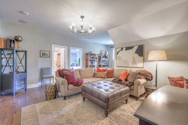 living room featuring baseboards, a chandelier, and hardwood / wood-style flooring