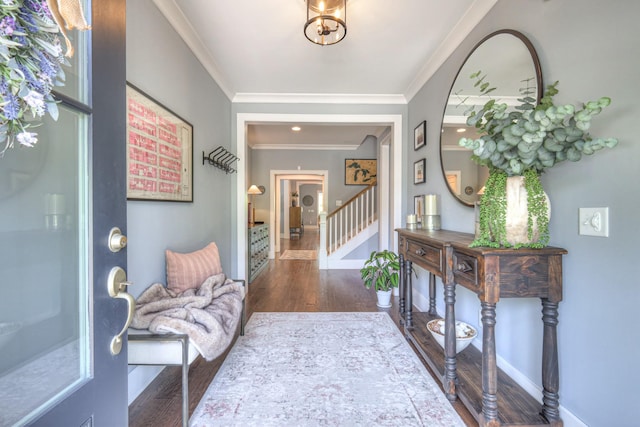 foyer entrance featuring crown molding, stairs, baseboards, and wood finished floors