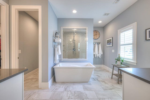 bathroom with vanity, marble finish floor, a freestanding tub, baseboards, and a tile shower