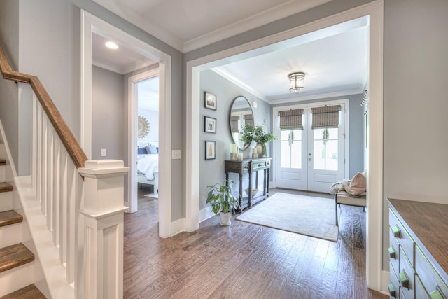 foyer entrance with french doors, ornamental molding, wood finished floors, and stairway