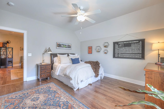 bedroom with baseboards, lofted ceiling, wood finished floors, and ceiling fan