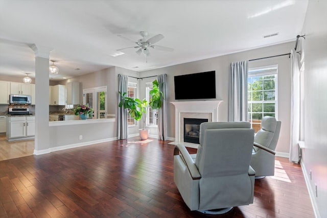 living room with a high end fireplace, ceiling fan, hardwood / wood-style floors, and visible vents
