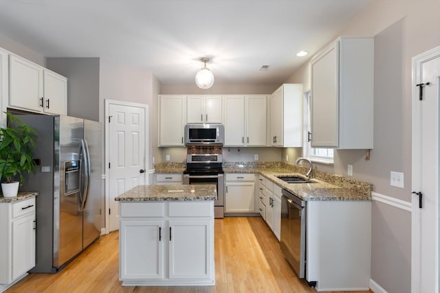 kitchen featuring stainless steel appliances, white cabinetry, and a sink