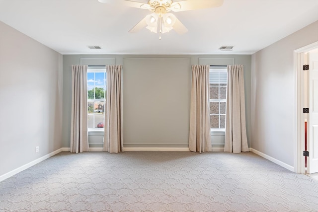 spare room with visible vents, a ceiling fan, baseboards, and carpet floors