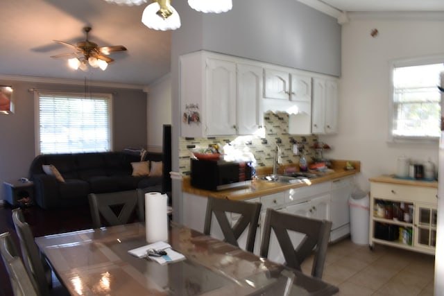 dining room featuring crown molding, a ceiling fan, and light tile patterned flooring