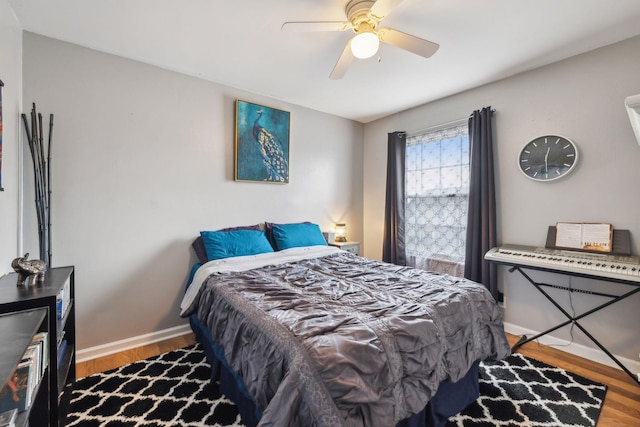 bedroom with baseboards, ceiling fan, and wood finished floors