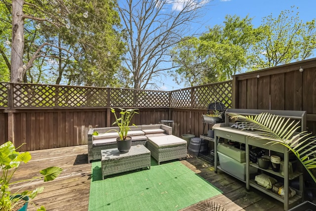 wooden terrace featuring an outdoor living space and a fenced backyard