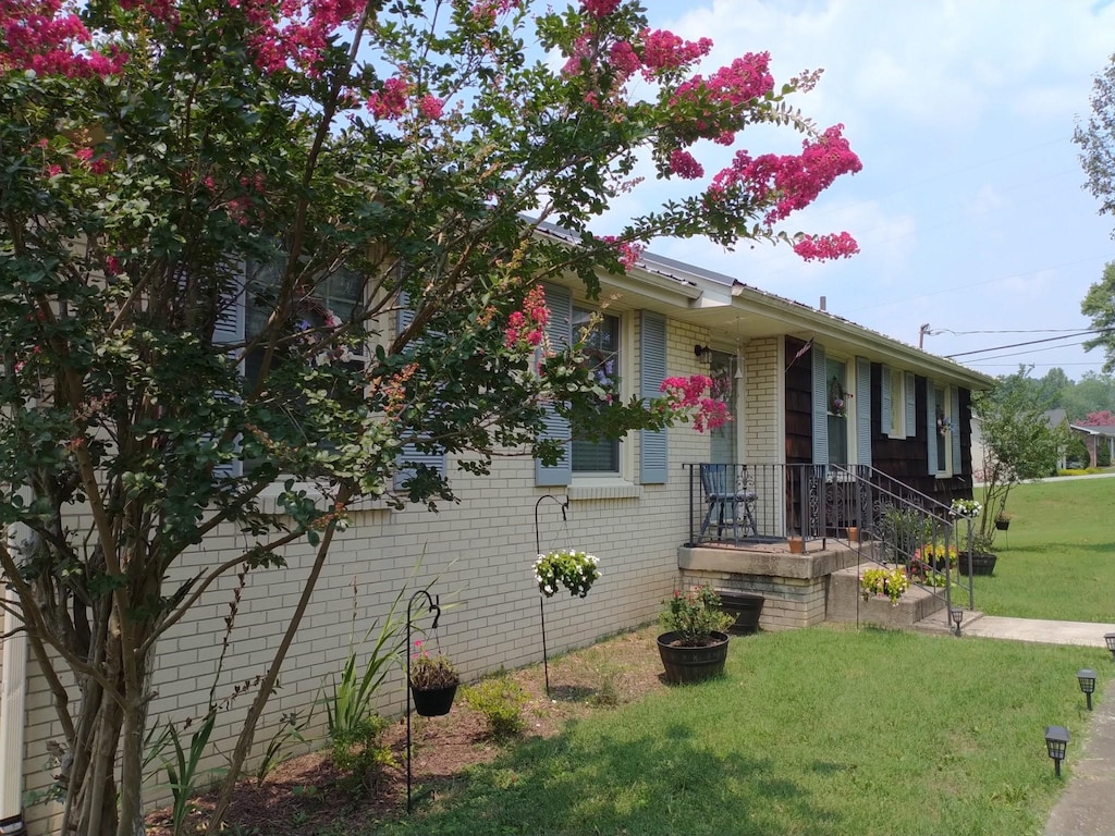 view of front of house featuring brick siding and a front lawn