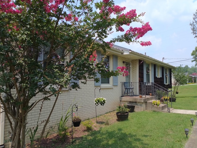view of front of house featuring brick siding and a front lawn