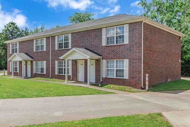 view of front of home featuring a front yard and brick siding
