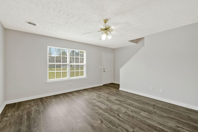 unfurnished living room featuring ceiling fan, a textured ceiling, visible vents, wood finished floors, and baseboards