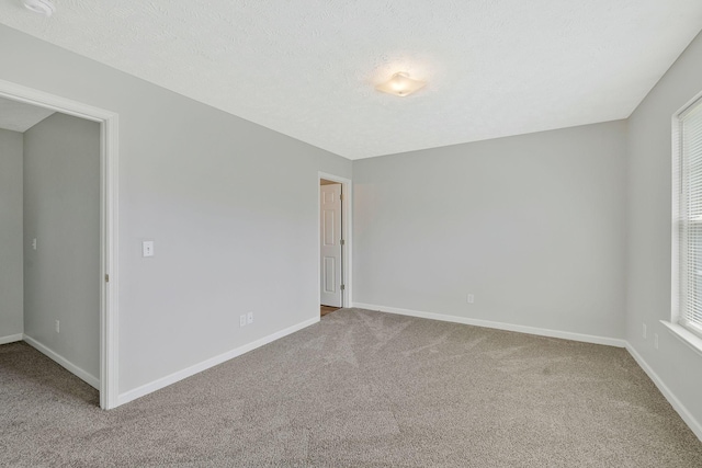spare room with baseboards and carpet flooring