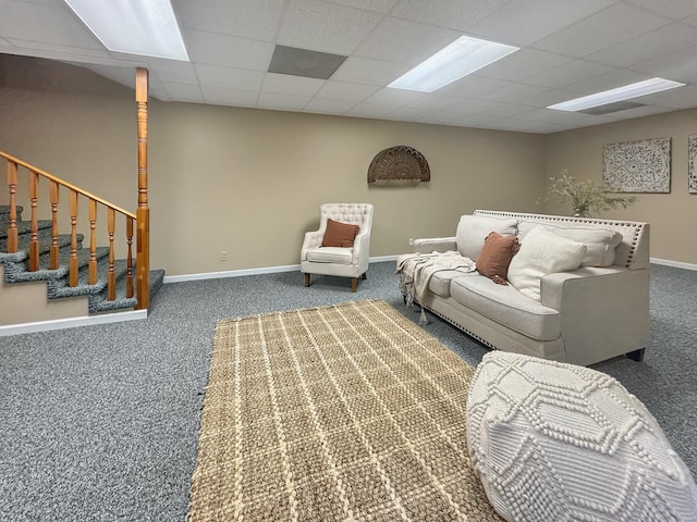 living room with carpet flooring, baseboards, and a drop ceiling