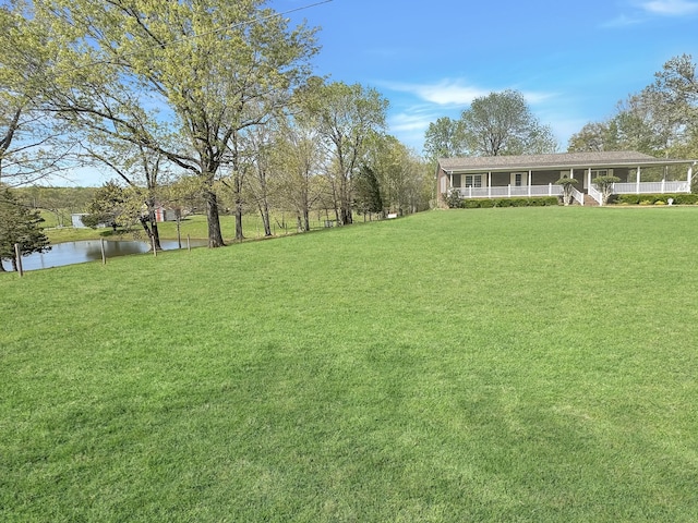 view of yard featuring covered porch and a water view