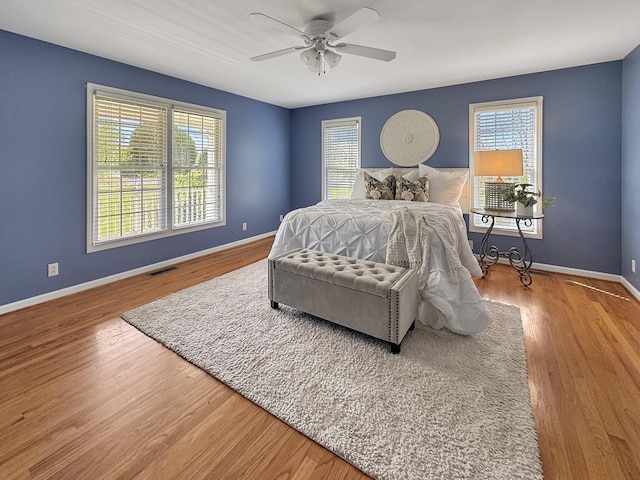 bedroom with baseboards, visible vents, and multiple windows