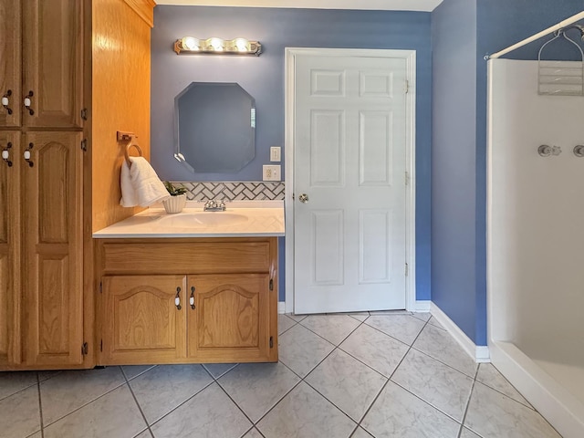 full bath with vanity, decorative backsplash, tile patterned flooring, a shower, and baseboards