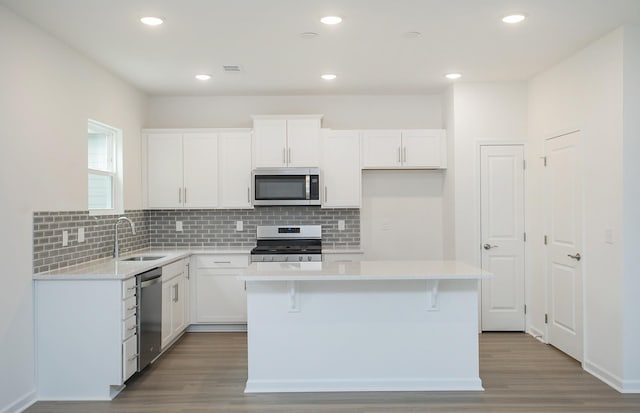 257 Brook Ave, White House, TN 37188 - kitchen with a center island, stainless steel appliances, wood finished floors, and white cabinetry