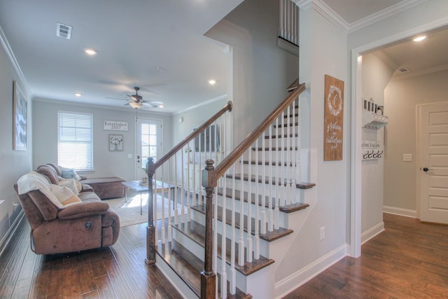 staircase with ceiling fan, visible vents, ornamental molding, and wood finished floors