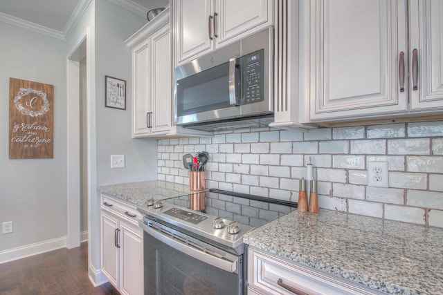 kitchen with crown molding, appliances with stainless steel finishes, light stone counters, dark wood-type flooring, and backsplash
