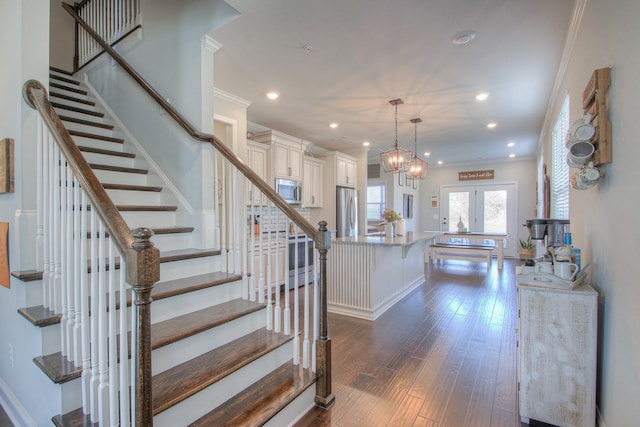 staircase featuring crown molding, wood finished floors, baseboards, recessed lighting, and french doors