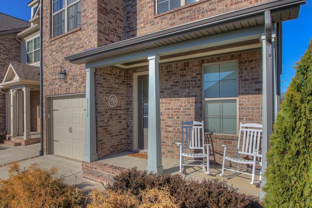 property entrance featuring brick siding, an attached garage, and a porch