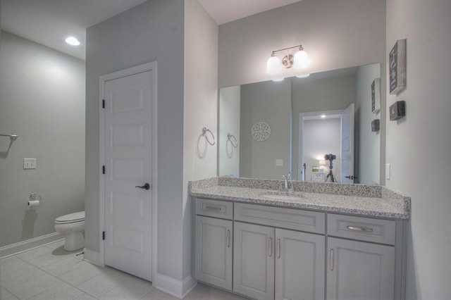 bathroom with toilet, baseboards, tile patterned floors, and vanity