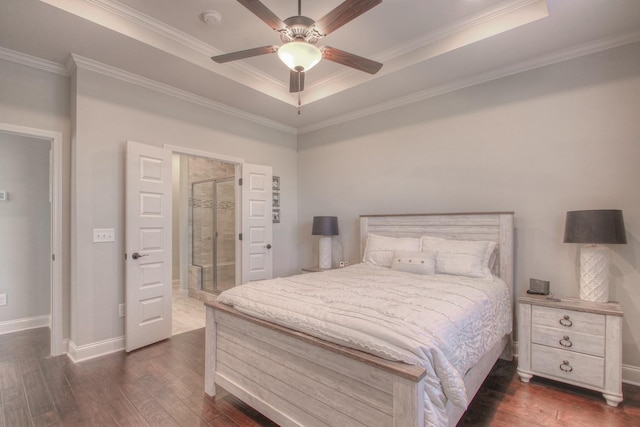 bedroom with crown molding, a tray ceiling, and dark wood-style flooring