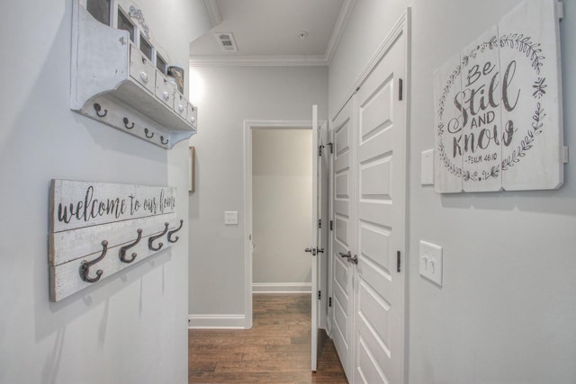 interior space featuring baseboards, ornamental molding, wood finished floors, and visible vents