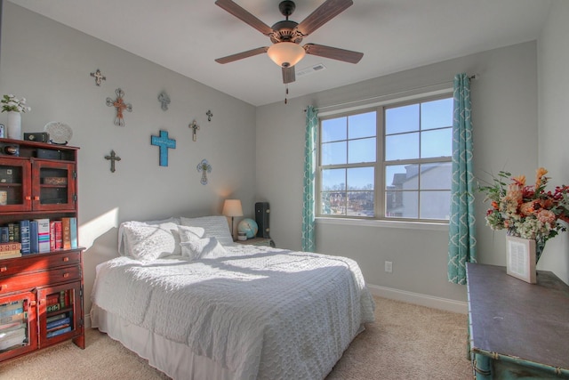 bedroom featuring visible vents, baseboards, ceiling fan, and light carpet