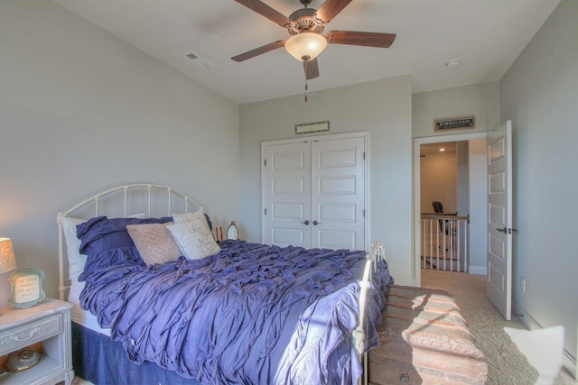 carpeted bedroom with ceiling fan, visible vents, and a closet