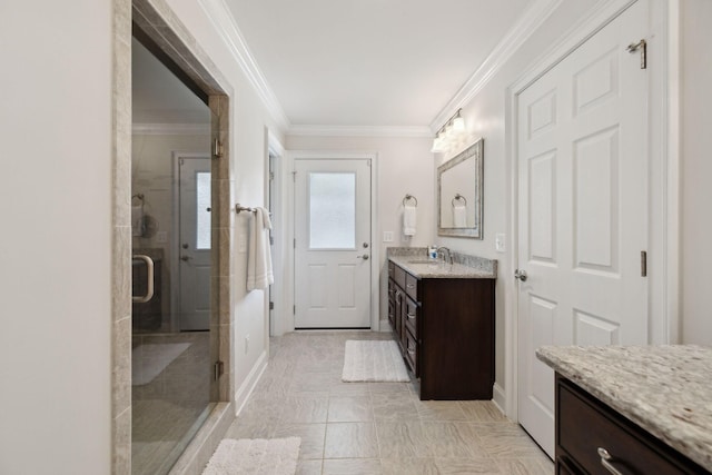 full bathroom featuring crown molding, vanity, baseboards, and a shower stall