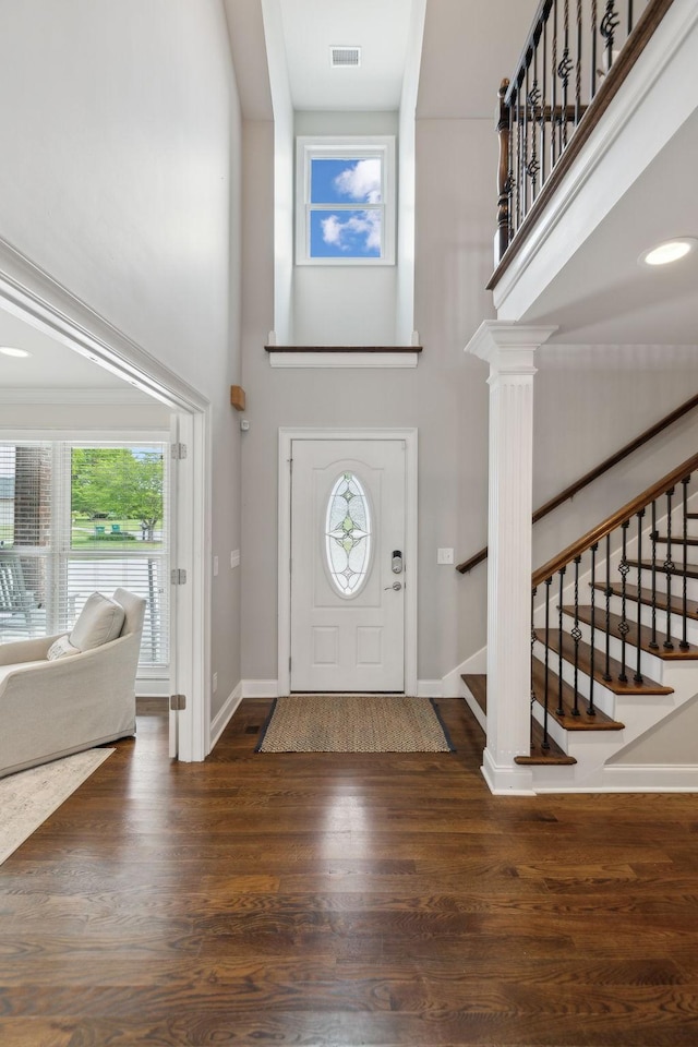 foyer entrance with a high ceiling, baseboards, and stairway