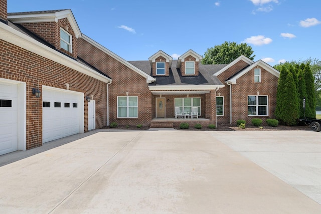 view of front facade with a porch, brick siding, and driveway